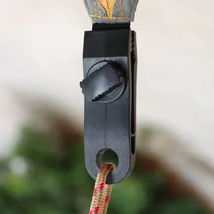 Dettaglio di una clip per tenda robusta con manopola di regolazione e attacco paracord