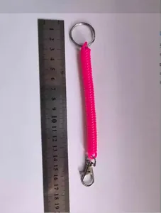 Vue détaillée du porte-clés à ressort rose mesurant environ 16 cm avec une règle.