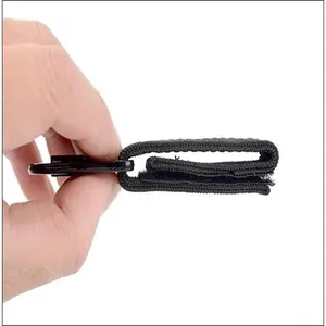 Side view detail of a black tactical eagle beak webbing clip with nylon strap and velcro.
