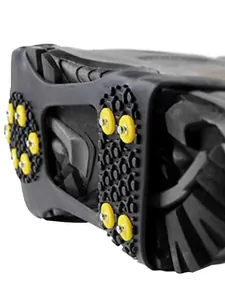 Detail view of yellow anti-slip studs on durable rubber ice cleats for snow hiking.