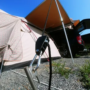 Detailopname van de tenttouwspanner met katrol en karabijnhaak bij outdoor kamperen