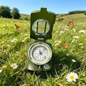 Professional military green tactical compass with luminous dial in an outdoor meadow.