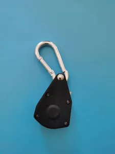 Close-up van een zwarte plastic katrol touwspanner met een zilveren karabijnhaak.