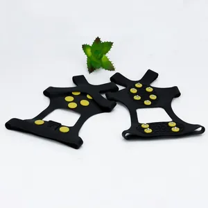 Detailed view of black rubber ice cleats with yellow anti-slip studs for snow hiking.
