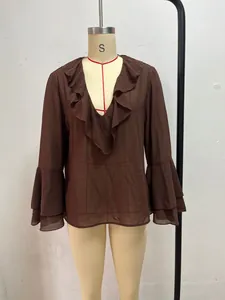Detalle de blusa marrón con volantes, cuello en V y mangas acampanadas en maniquí