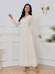 Robe maxi élégante de couleur crème à manches longues avec col V et détails dorés.