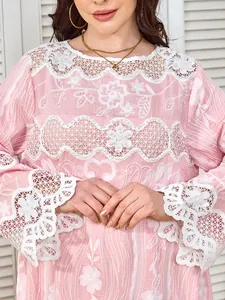 Detailed view of pink floral embroidery and white pearl accents on elegant lace dress