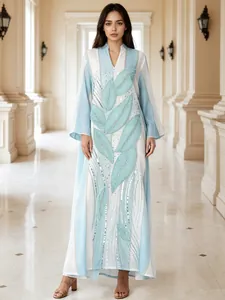 Dettaglio di un elegante abito lungo a righe con paillettes a forma di foglia