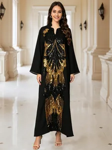 Detail of elegant black maxi dress with intricate gold and black sequin butterfly embroidery.