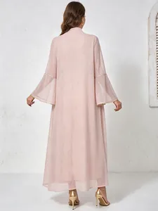 Vue arrière d'une robe longue rose scintillante avec manches cloche évasées et talons dorés élégants.