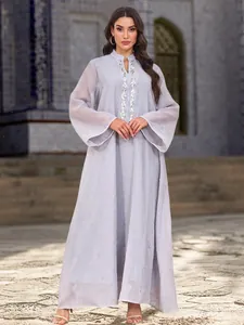 Détail d'une élégante robe longue abaya grise en résille avec broderies de perles argentées