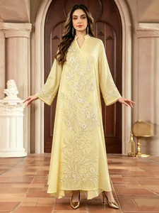 Gros plan d'une élégante robe maxi ethnique jaune avec des broderies de perles argentées