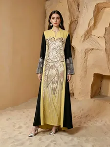 Vue complète d'une élégante robe maxi ethnique avec appliques de perles dorées sur sable.