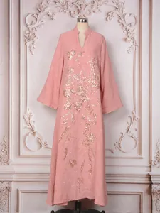 Détail d'une élégante robe longue rose avec broderie florale à paillettes miroitantes