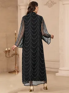 Vue arrière détaillée d'une robe longue noire élégante avec des strass argentés.