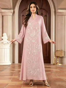 Robe longue ethnique rose élégante ornée de perles blanches et de détails complexes en paillettes