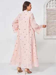 Dettaglio posteriore di un abito lungo in rete rosa ricamato con perline eleganti.