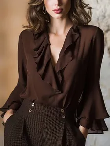 Detalle de blusa marrón con elegantes volantes en capas y sofisticado cuello en V