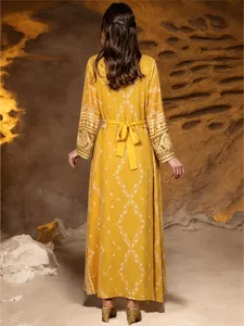Rear view of elegant yellow Malaysian robe with intricate white embroidery and waist tie
