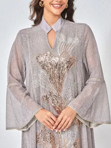 Détail d'une robe grise de luxe avec broderie complexe de paillettes et de perles.