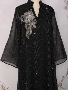 Détail d'une élégante robe longue noire avec des motifs de strass et de perles