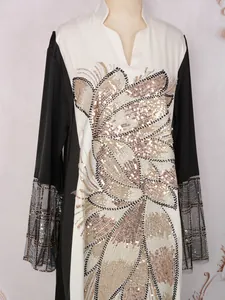 Détail de robe ethnique à manches longues avec appliqué pailleté doré et poignets en résille