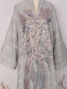 Primer plano de un vestido largo gris con cuello en V e intrincados detalles de lentejuelas
