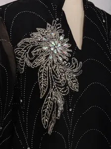 Gros plan d'une robe noire élégante avec des perles argentées et motifs de paillettes