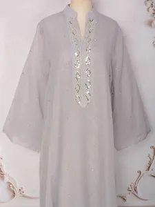 Détail d'une abaya en maille grise avec broderies raffinées en strass et perles
