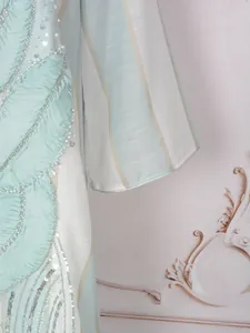 Dettaglio dell'elegante abito etnico azzurro con ricami floreali in perline e paillettes