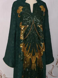 Close-up detail of heavy sequin butterfly embroidery on elegant green party dress