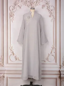 Détail d'une robe longue élégante avec strass et perles sur un mannequin d'exposition