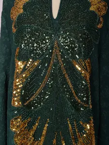 Detail shot of heavy beadwork and sequin butterfly embroidery on dark green party dress
