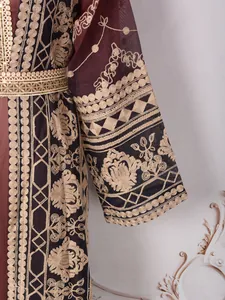 Close-up of elegant golden embroidery on dark maroon fabric of a Malaysian style robe