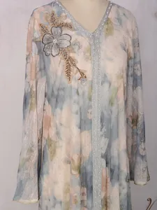 Gros plan d'une robe à fleurs élégante avec broderie de perles et détails en strass