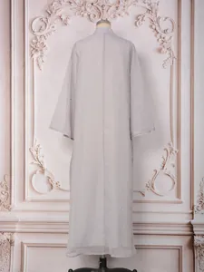Vue arrière d'une robe longue grise élégante avec motifs de perles en strass ondulés.