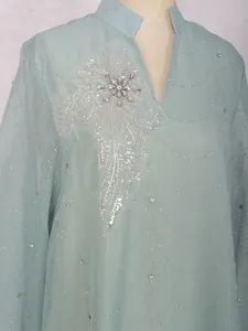 Gros plan d'une robe bleu clair élégante avec broderies complexes de paillettes et de perles