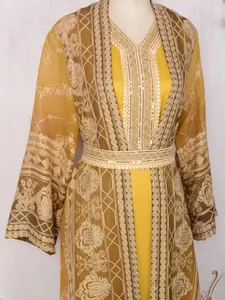 Close-up of elegant Malaysian-style kaftan with intricate golden embroidery and sequins