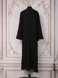 Back view of elegant black evening dress with heavy sequin embroidery and wide gold-trimmed sleeves