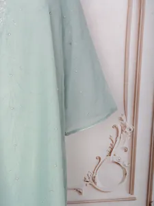 Gros plan de la robe vert menthe avec motifs de strass élégants en forme de vagues