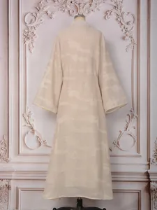 Vista trasera de un elegante vestido largo de manga larga color champán en un maniquí de costura