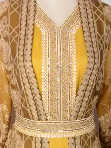 Close-up of elegant embroidery and gold sequin details on a yellow Malaysian robe.