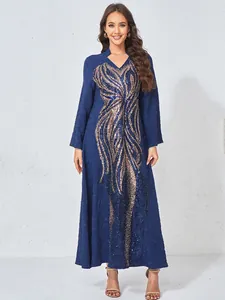 Detail view of navy blue evening gown with gold sequined embroidery and lace texture