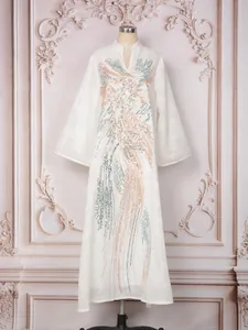 Primer plano de un elegante vestido caftán blanco con cuello en V y bordados de lentejuelas.