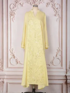 Vue détaillée des perles dorées et des paillettes sur cette élégante robe jaune longue.