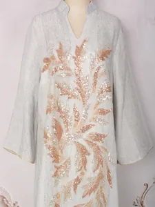 Detail of elegant V-neck dress featuring rose gold sequin floral applique