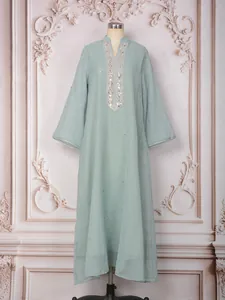 Caftan turc vert menthe avec broderies de perles complexes et tissu en maille fine.