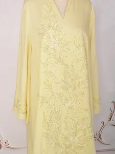 Détail d'une robe ethnique jaune ornée de broderies de perles et de sequins complexes