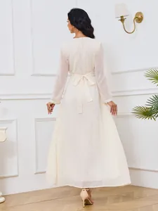 Vue arrière d'une robe longue crème à manches longues avec pois dorés et ceinture