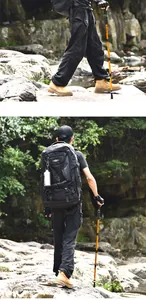 Detailansicht eines Wanderers mit Cleye-Aluminium-Trekkingstock und schwarzem Rucksack